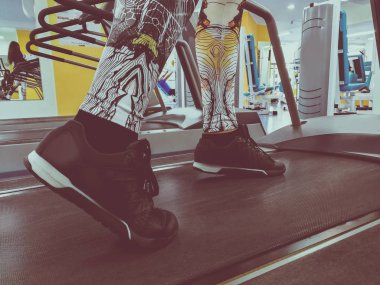 bir koşu bandı üzerinde spor ayakkabı ayaklar