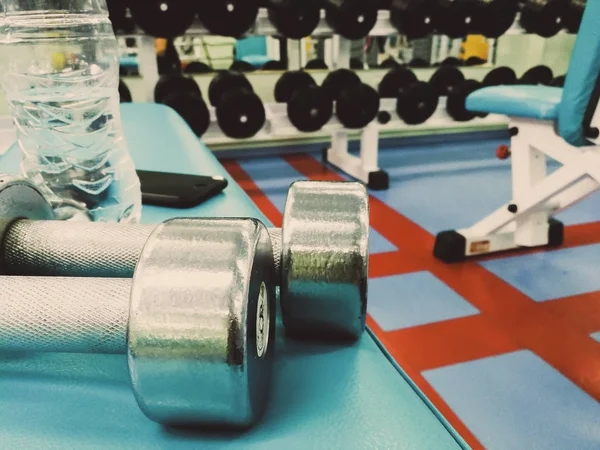 Dumbbells en water in de sportschool — Stockfoto