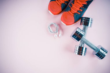 spor konsepti: spor ayakkabıları, halter, pembe backgr kulaklık