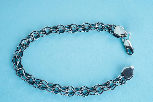 Срібний браслет на синьому фоні — стокове фото