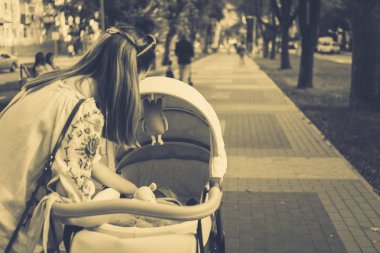 Anne üzerinde bir bebek arabası