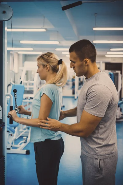 The concept of personal training. Coach and client in the gym