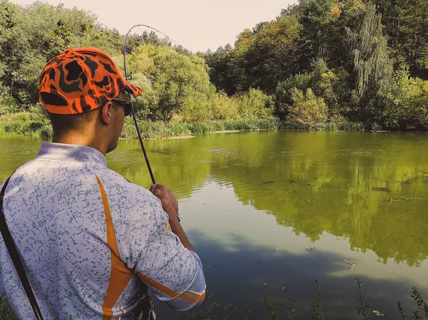 Der Fischer fischt im Sommer auf dem See — Stockfoto