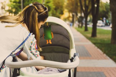 Anne üzerinde bir bebek arabası