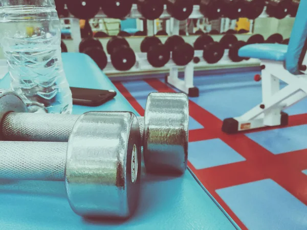 Dumbbells and water in the gym — Stock Photo, Image