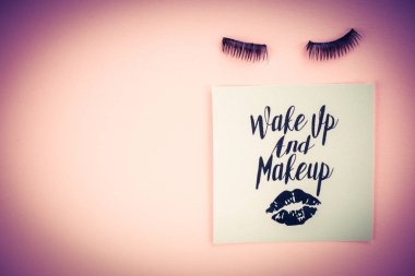 Pembe bir arka plan üzerinde çeşitli makyaj ürünleri