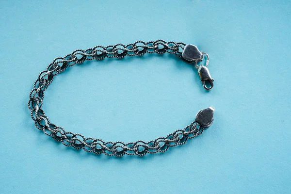 Silver bracelet on a blue background — Stock Photo, Image