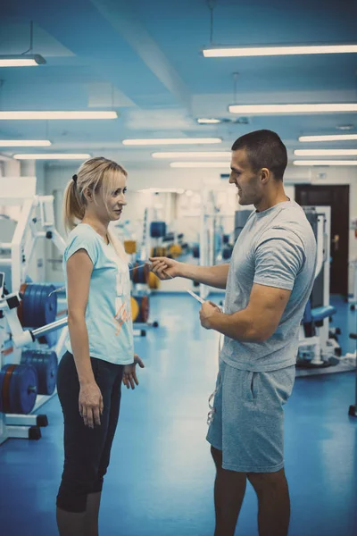 El concepto de entrenamiento personal. Entrenador y cliente en el gimnasio —  Fotos de Stock