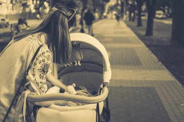 Anne üzerinde bir bebek arabası