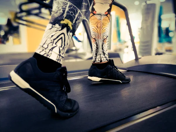 feet in sneakers on a treadmill