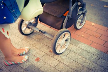 Anne üzerinde bir bebek arabası