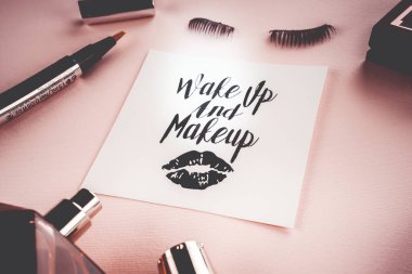 Pembe bir arka plan üzerinde çeşitli makyaj ürünleri