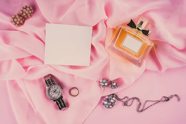 Various makeup products on pink background