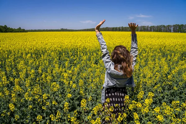 Een meisje in een veld met koolzaad — Stockfoto