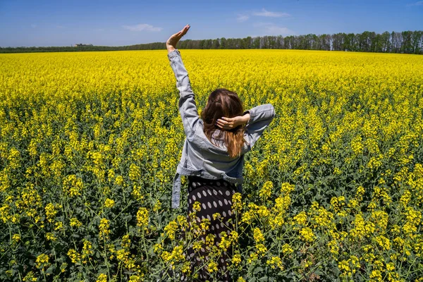 Een meisje in een veld met koolzaad — Stockfoto