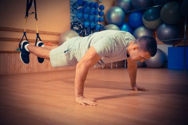 Genç adam bir spor salonunda trx devreye girer