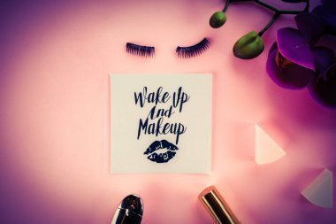 Pembe bir arka plan üzerinde çeşitli makyaj ürünleri