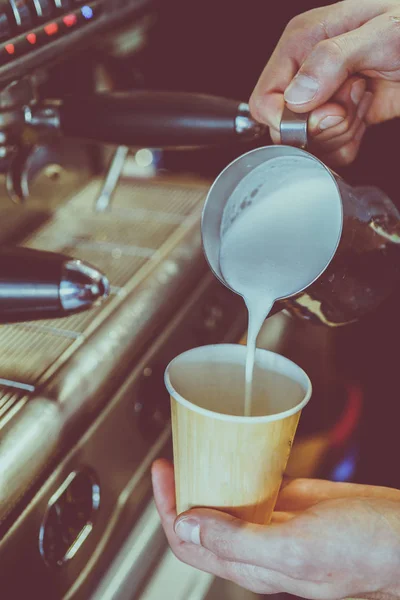 Milch wird in Kaffee gegossen — Stockfoto