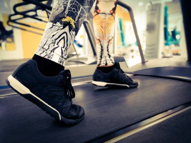 bir koşu bandı üzerinde spor ayakkabı ayaklar