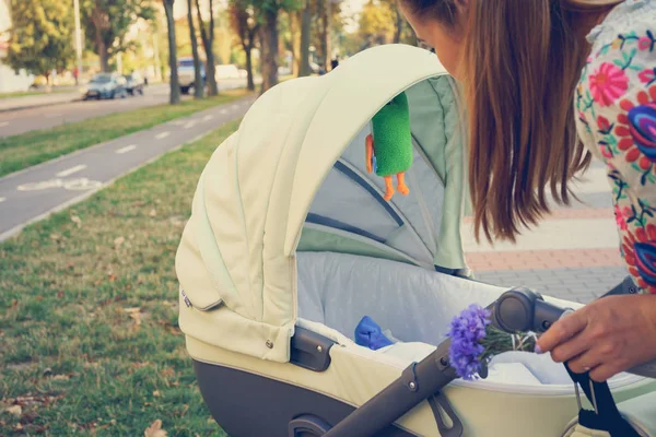 Moeder over een wandelwagen — Stockfoto