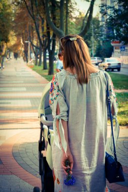 Anne üzerinde bir bebek arabası