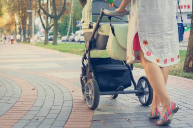 bir yürüyüşte bir bebek arabası ile anne