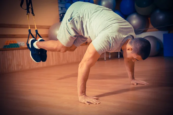 Ung man är engagerad i ett gym i trx — Stockfoto