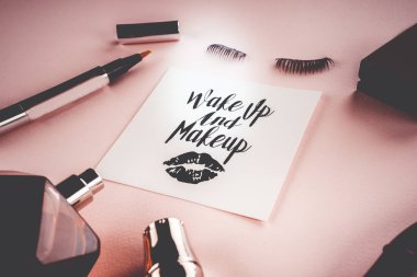 Pembe bir arka plan üzerinde çeşitli makyaj ürünleri