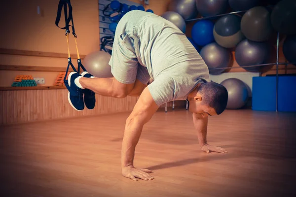 Ung man är engagerad i ett gym i trx — Stockfoto