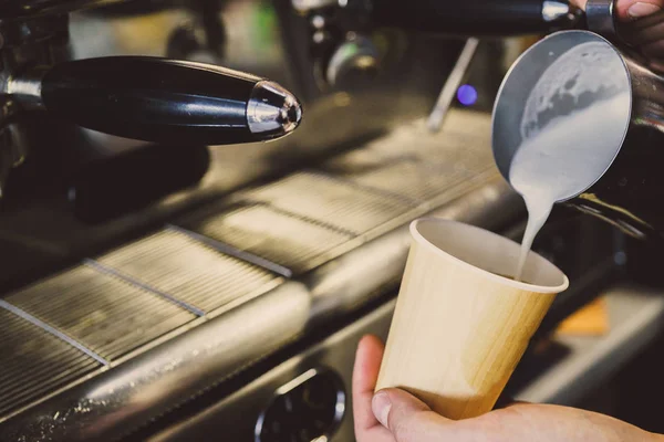 Milch wird in Kaffee gegossen — Stockfoto