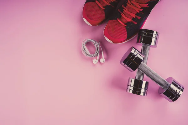 Спортивная концепция: кроссовки, гантели, наушники на розовом бэкгре — стоковое фото