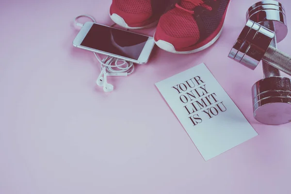 Кросівки, телефон і гантелі на рожевому фоні — стокове фото