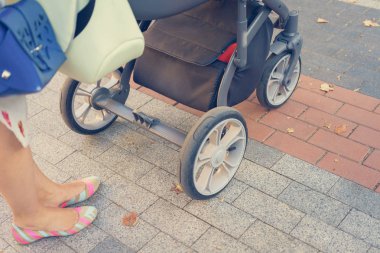 Anne üzerinde bir bebek arabası