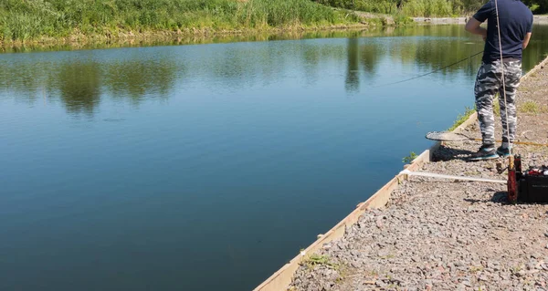 Pescatore cattura trota iridea dal lago — Foto Stock