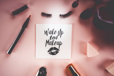 Pembe bir arka plan üzerinde çeşitli makyaj ürünleri