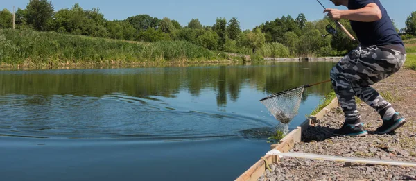 Fisherman catch rainbow trout from lake — Stock Photo, Image