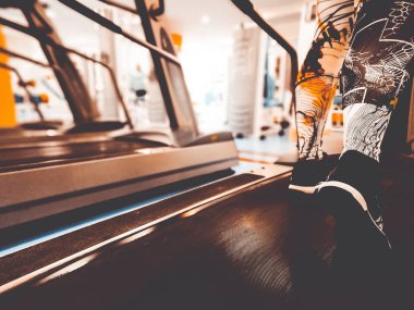 bir koşu bandı üzerinde spor ayakkabı ayaklar