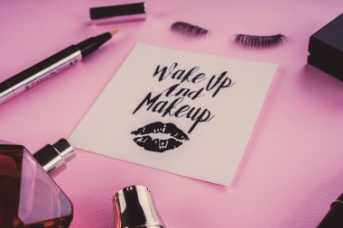 Pembe bir arka plan üzerinde çeşitli makyaj ürünleri