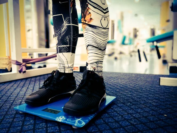 spor salonunda terazi üzerinde ayaklar