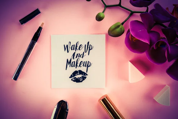 Make-up tools op een roze achtergrond en de orchideebloem — Stockfoto