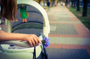 Anne üzerinde bir bebek arabası