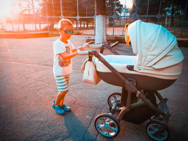 Hermano camina con un cochecito. Familia — Foto de Stock