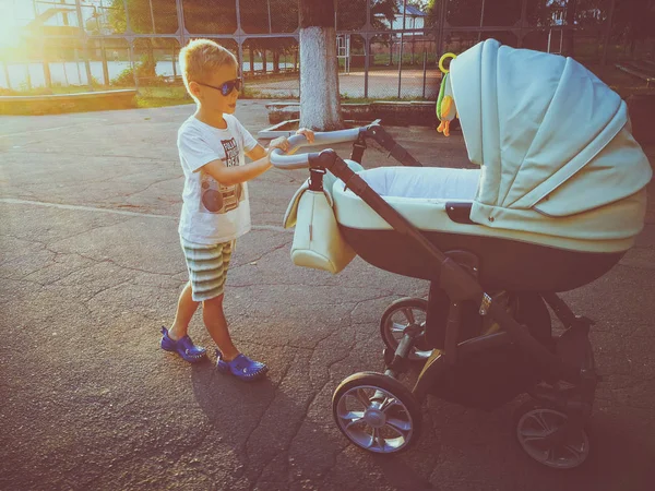 Hermano camina con un cochecito. Familia — Foto de Stock