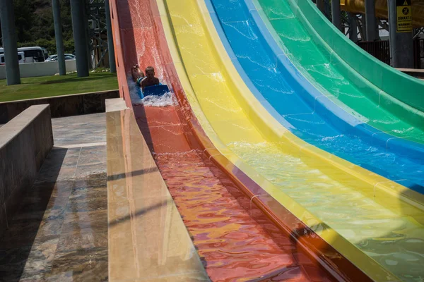 De jongen rijdt een dia in het waterpark — Stockfoto