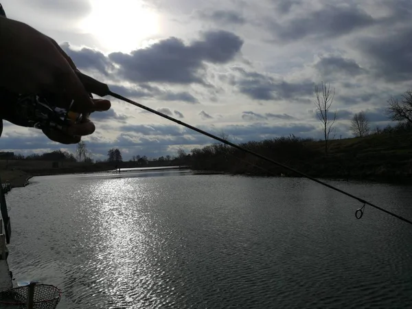 年轻人在湖边钓鱼 — 图库照片