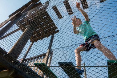 Çocuk ip parkında oynuyor.