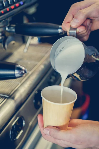 Milch wird in Kaffee gegossen — Stockfoto