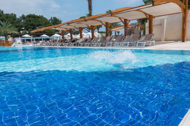 Çocuk havuza atlıyor.