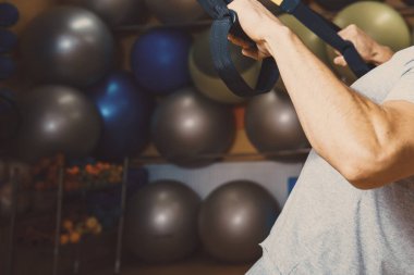 Genç adam bir spor salonunda trx devreye girer