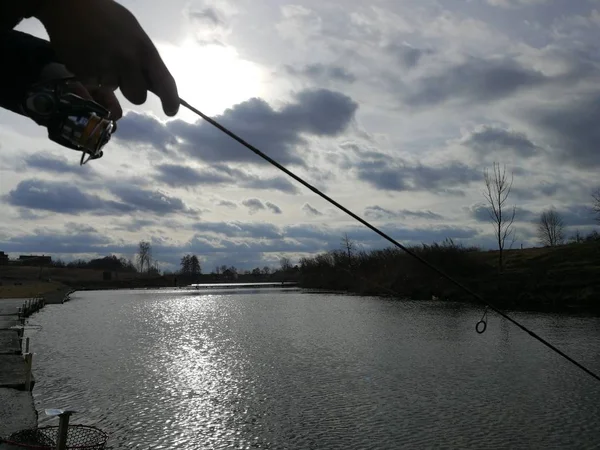 年轻人在湖边钓鱼 — 图库照片